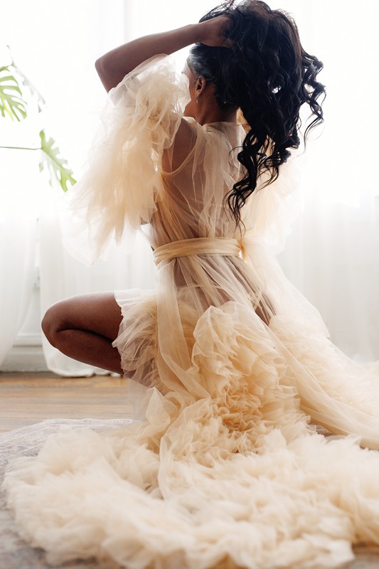 woman in sheer robe plays with hair during a boudoir photoshoot at studio in wicker park chicago.