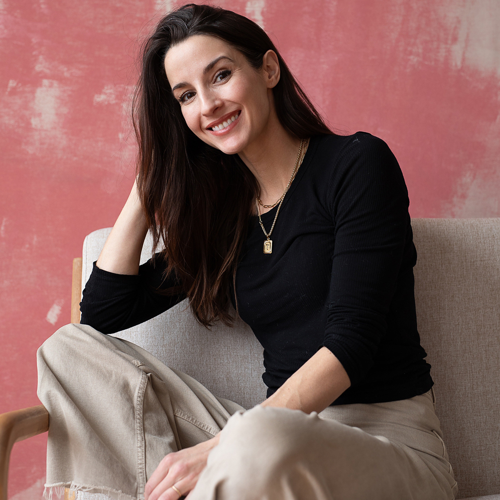 Photographer Maggie Rife Ponce sits on a couch at her wicker park boudoir photo studio